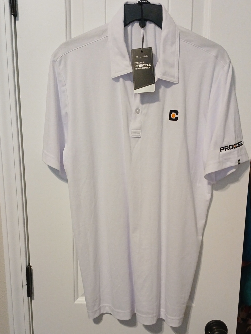 Travis Mathew White Polo with Small Black and Orange Logo